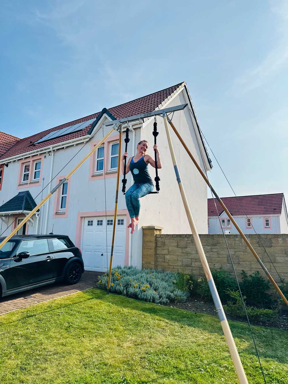 Debbie site in the trapeze seat to demo the Air frame Large in her garden .